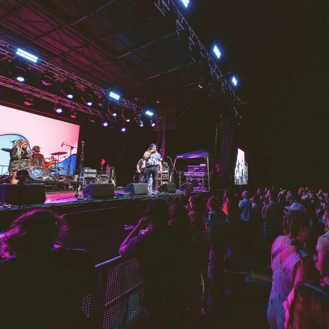 Musicians performing on a large concert stage in front of an audience